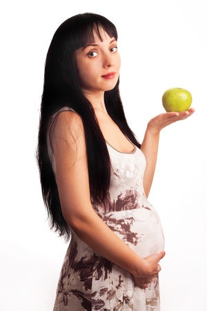 Beautiful, young pregnant girl is eating an Apple. Mom, Mother, Motherhood, waiting for the child birth.の写真素材