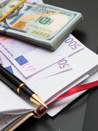 Pack of banknotes against a notebook and the handle の写真素材