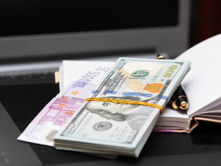 Pack of banknotes against a notebook and the handle 