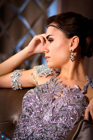 young beautiful girl in a shiny dress in the roomの写真素材