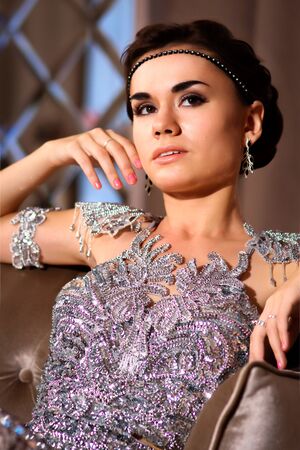 young beautiful girl in a shiny dress in the roomの写真素材