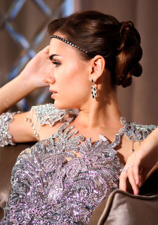 young beautiful girl in a shiny dress in the roomの写真素材