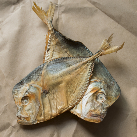 snack for beer. salted dried fish lies on brown paper.の写真素材