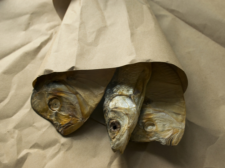 snack for beer. salted dried fish lies on brown paper.の写真素材