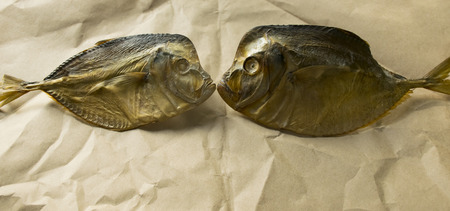 snack for beer. salted dried fish lies on brown paper.の写真素材