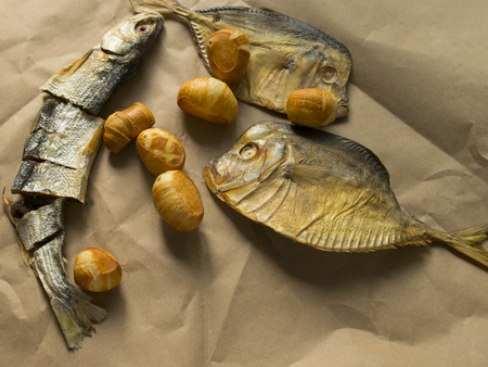 snack for beer. salted dried fish lies on brown paper.の写真素材