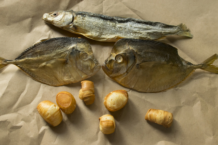 snack for beer. salted dried fish lies on brown paper.の写真素材
