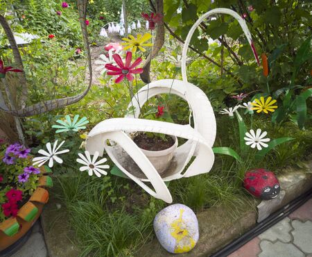 A flower from a plastic bottle. Mushroom from old pans. Swan from the bus. Decoration for the garden do it yourself. Reuse plastic. The decor of the waste.の写真素材