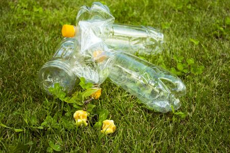 Plastic bottles lie on the green grass. Pollution of nature. Rubbish on the lawn.の写真素材