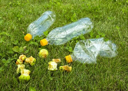 Plastic bottles lie on the green grass. Pollution of nature. Rubbish on the lawn.の写真素材