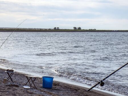 Fisherman fishes early in the morning on the shore. Fishing rod and spinning. Campingの写真素材