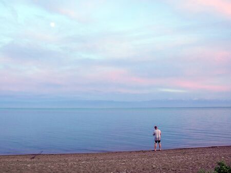 Fisherman fishes early in the morning on the shore. Fishing rod and spinning. Campingの写真素材