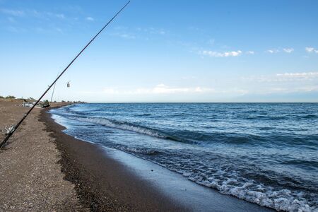Fisherman fishes early in the morning on the shore. Fishing rod and spinning. Campingの写真素材