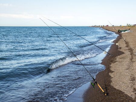Fisherman fishes early in the morning on the shore. Fishing rod and spinning. Campingの写真素材