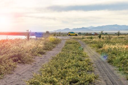 A dirt road leads to a wild beach. Camping in a tent. Beautiful place. Wild tourism. Journey.の写真素材