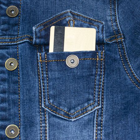 Denim jacket pocket with stitches. Casual wear. Jean jacket. A plastic credit card sticks out of his pocketの写真素材
