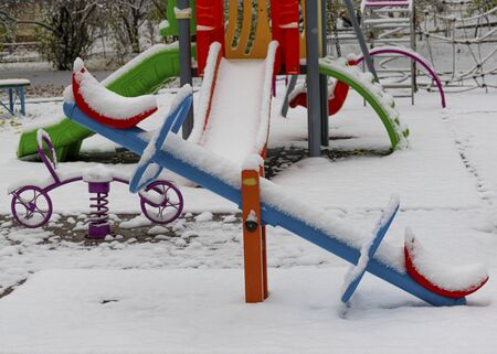 The playground is covered in snow. Children's slide and stairs. Happy childhood. Winter and snowfall.の写真素材