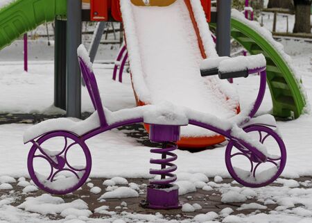 The playground is covered in snow. Children's slide and stairs. Happy childhood. Winter and snowfall.の写真素材