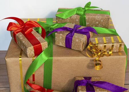 Gifts packed in craft paper and tied with satin ribbon on a wooden background. Birthday presents, new year and christmas. Surprise for the holiday.の写真素材