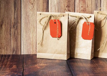 Vintage handmade gift boxes made of kraft paper on a wooden background in the Christmas style,...