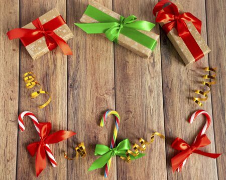 Christmas baubles, fir branches, gift, balls for the Christmas tree, candy canes, paper for text on a brown wooden table. Christmas wooden background. New Year, Christmas, winter holiday, copy spaceの写真素材