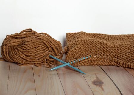 Handwork and craft. Knitting with brown yarn. A ball of thread. Needlework