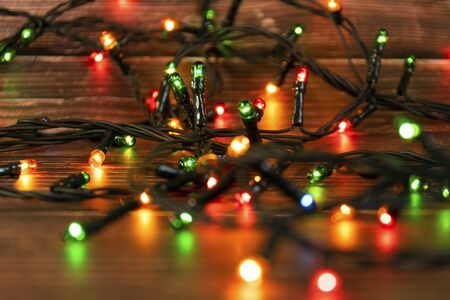 Colorful christmas garland lights on brown wooden background. Christmas Light with Copyspace for New...