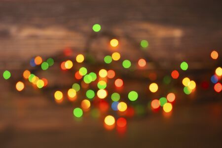 Colorful christmas garland lights on brown wooden background. Christmas Light with Copyspace for New...