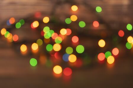 Colorful christmas garland lights on brown wooden background. Christmas Light with Copyspace for New Year Frame or Christmas Layout. New Year. Christmas decorations showcasesの写真素材