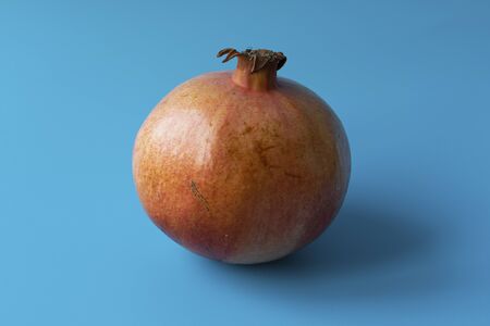 Ripe juicy sweet pomegranate on a blue background. Fruits and vitamins.の写真素材