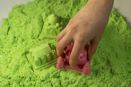 Kinetic sand. A child plays with kinetic sand. Fine motor skills, creativity, games.の写真素材