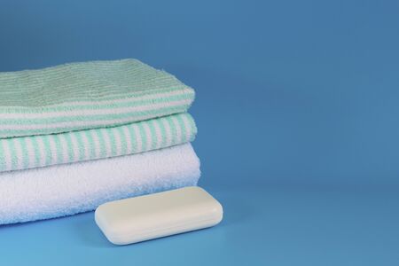 Soft and fluffy towels on a blue background. Soap for bath, laundry and body care. Personal hygiene products. Bath amenities, spaの写真素材