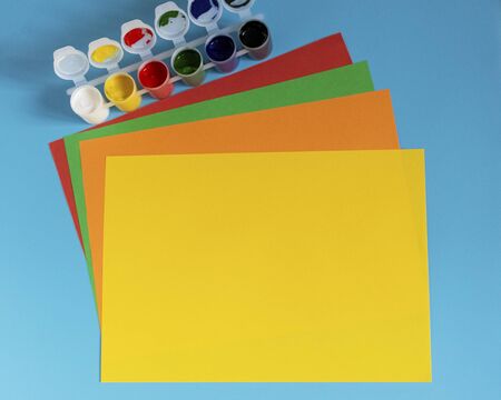 Stack of multi-colored paper and paint for drawing on a blue background.
の写真素材