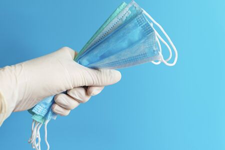 Surgical medical mask. Mask to protect the mouth and nose from bacteria
and the virus. Doctor's hands in disposable gloves.の写真素材