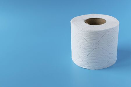 Roll of toilet paper on a blue background. Personal hygiene item for the bathroom