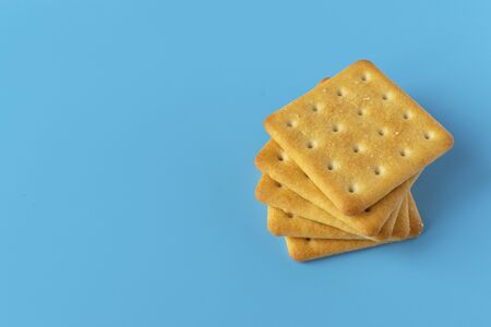 Crispy cracker on a blue background. Salty tea biscuits. Healthy Diet Snack.の写真素材