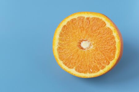 Ripe juicy orange on a blue background. Citrus fruit. Vitamins and Food for Vegetarians.