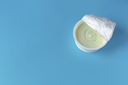 Yogurt in a glass on a blue background. A wholesome light diet breakfast. Dairy products.