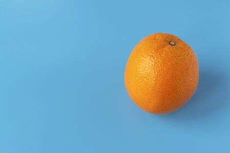 Ripe juicy orange on a blue background. Citrus fruit. Vitamins and Food for Vegetarians.
の写真素材