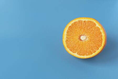 Ripe juicy orange on a blue background. Citrus fruit. Vitamins and Food for Vegetarians.の写真素材
