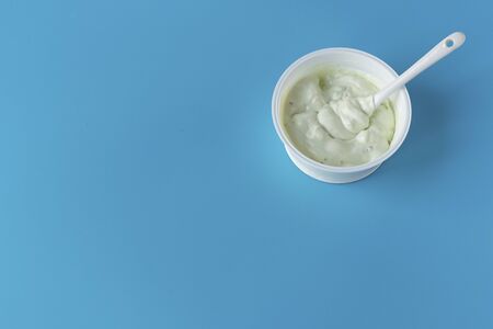 Yogurt in a glass on a blue background. A wholesome light diet breakfast. Dairy products.の写真素材