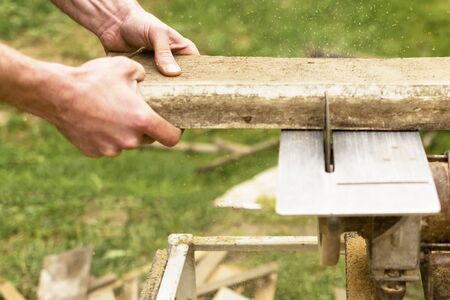 Construction contractor worker using a worm-driven hand-held circular saw to cut boards.の写真素材