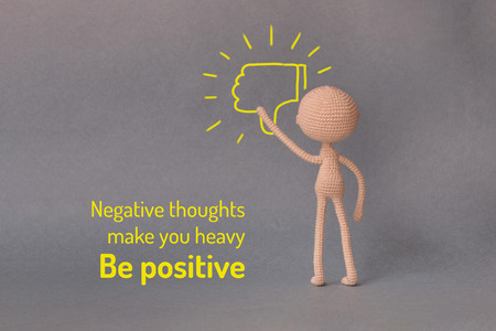 A toy man on a gray background with copy space. Motivational phrase. A sketch is drawn on top of the photo.A person presses the Dislike button.の写真素材