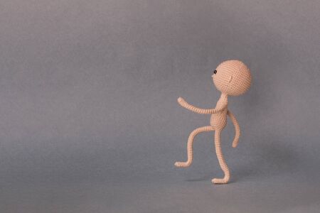 A toy man on a gray background with copy space. It's worth sideways view conceptの写真素材