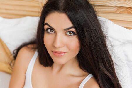 Portrait of beautiful young woman on bedの写真素材