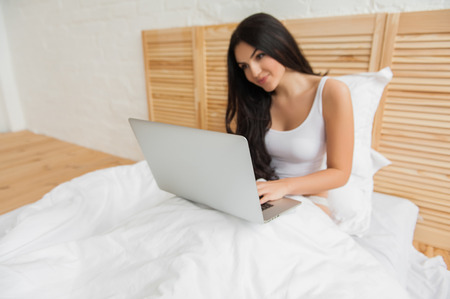 Young attractive girl with a laptop, focus on laptopの写真素材
