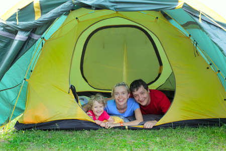 Happy family in tent on the natureの写真素材