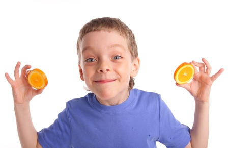 Boy with an orange on white backgroundの写真素材