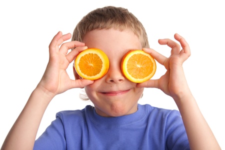 Boy with an orange on white backgroundの写真素材