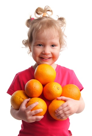 Happy little girl with oranges on a white backgroundの写真素材